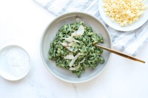 Zusehen sind selbstgemachte Käse-Spinat-Spätzle serviert auf einem weißen Teller