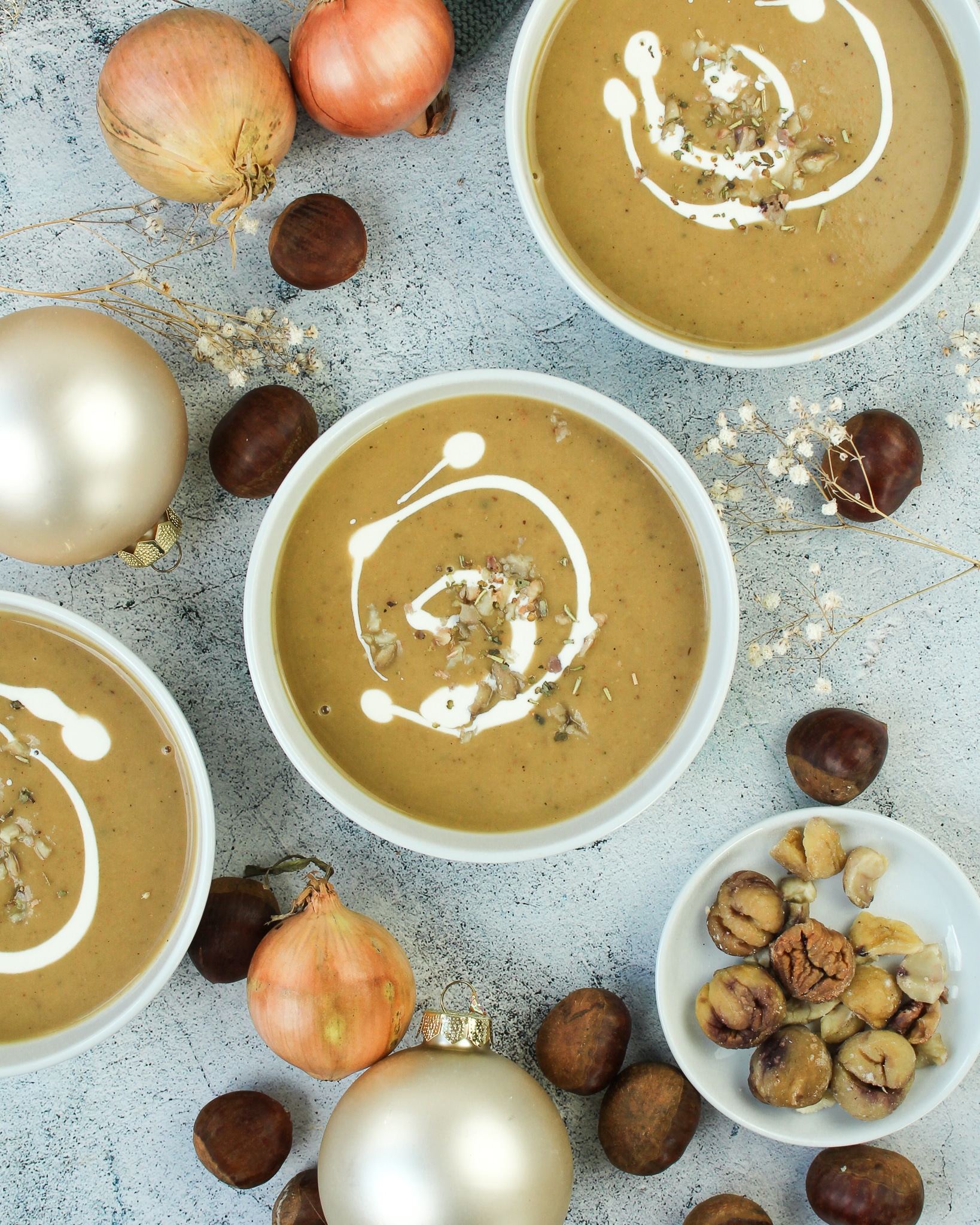 Auf dem Bild zusehen ist eine Vegane Maronensuppe mit Kartoffel auf einem herbstlich dekorieren Tisch