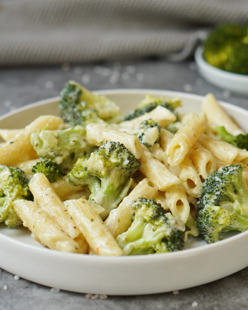 Hier ist eine Brokkoli Pasta auf einem weißen Teller zusehen 