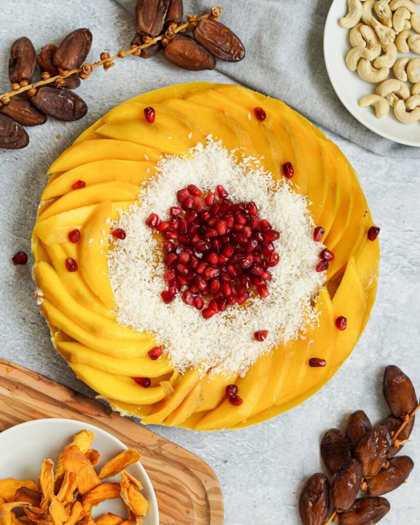 Zusehen ist eine vegane Rohkost Torte mit Mango und Granatapfelkernen